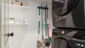 A laundry room with a washing machine, a drying machine, and a wall-mounted rack with cleaning supplies. - Home Away From Home in Nashville 3B 2B W/ Large Fenced in Back Yard (Nashville)