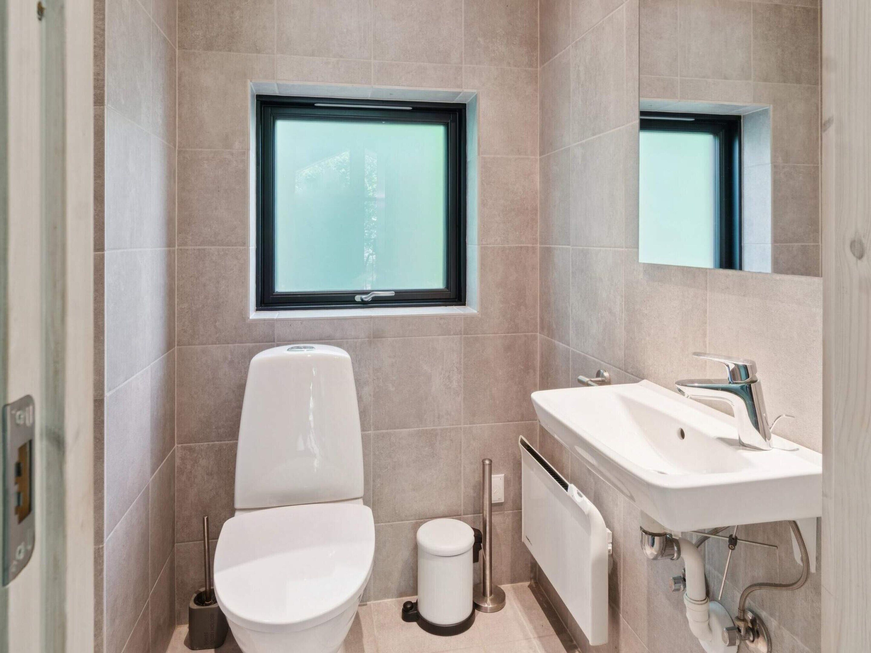 A modern bathroom with a toilet, bidet, and sink.