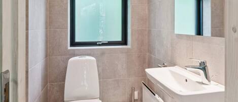 A modern bathroom with a toilet, bidet, and sink.
