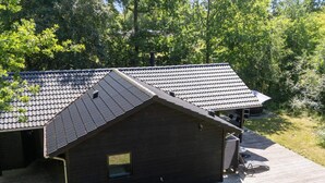 A modern building with a sloped roof, a wooden deck, and a small window. - 4 Star Holiday Home in Vig (Vig)
