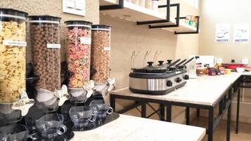 Un área de bufé con diferentes dispensadores de alimentos y una estación de café.