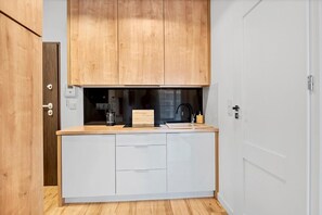 A compact kitchen with wooden cabinets, a countertop, and a sink. - House in Landunvez near Plage de Penfoul (Warszawa)
