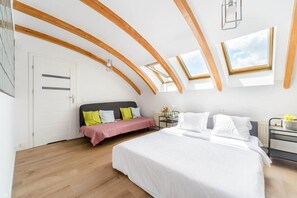 Ein Schlafzimmer mit einem großen Bett, einem Nachttisch, einem Sessel und einem Fenster mit Blick.