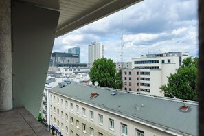 A view from a balcony overlooking a cityscape with modern buildings, including a hotel with a visible sign. - Elegant Central CIty Apartment in Warsaw (Warszawa 2)