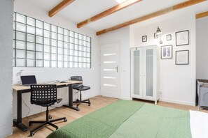 A room with a desk, two chairs, a green rug, a wardrobe, and a door with frosted glass panels. - House in Saint-Pabu near Stunning Beaches (Warszawa 2)