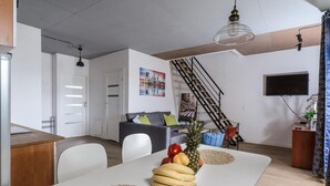 A modern living space with a dining area, a staircase, and a kitchen. - House in Saint-Pabu near Stunning Beaches (Warszawa 2)