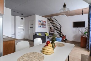 A modern living space with a dining area, a staircase, and a kitchen. - House in Saint-Pabu near Stunning Beaches (Warszawa 2)