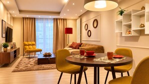A modern living room with a dining area, a sofa, a red floor lamp, and a television. - Central Warsaw Home with Pool (Warszawa)