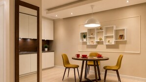 A modern dining area with a round table, two yellow chairs, and a pendant light. - Central Warsaw Home with Pool (Warszawa)