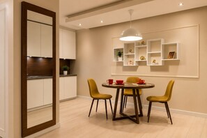 A modern dining area with a round table, two yellow chairs, and a pendant light. - Central Warsaw Home with Pool (Warszawa)