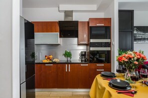 Eine moderne Küche mit Holdekor, Edelstahlgeräten und einem Essbereich, der für eine Mahlzeit gedeckt ist.
