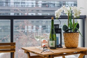 A table with a bottle of white wine, two glasses, a box of La Fiarello, and a potted orchid. - Apartment in Porspoder near Plage du Bourg (Warszawa 2)