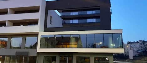 Un edificio de varios pisos con grandes ventanales y techo plano.