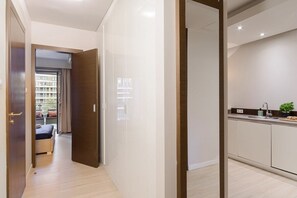 Un interior modern amb un passadís que condueix a una habitació i una zona de cuina.