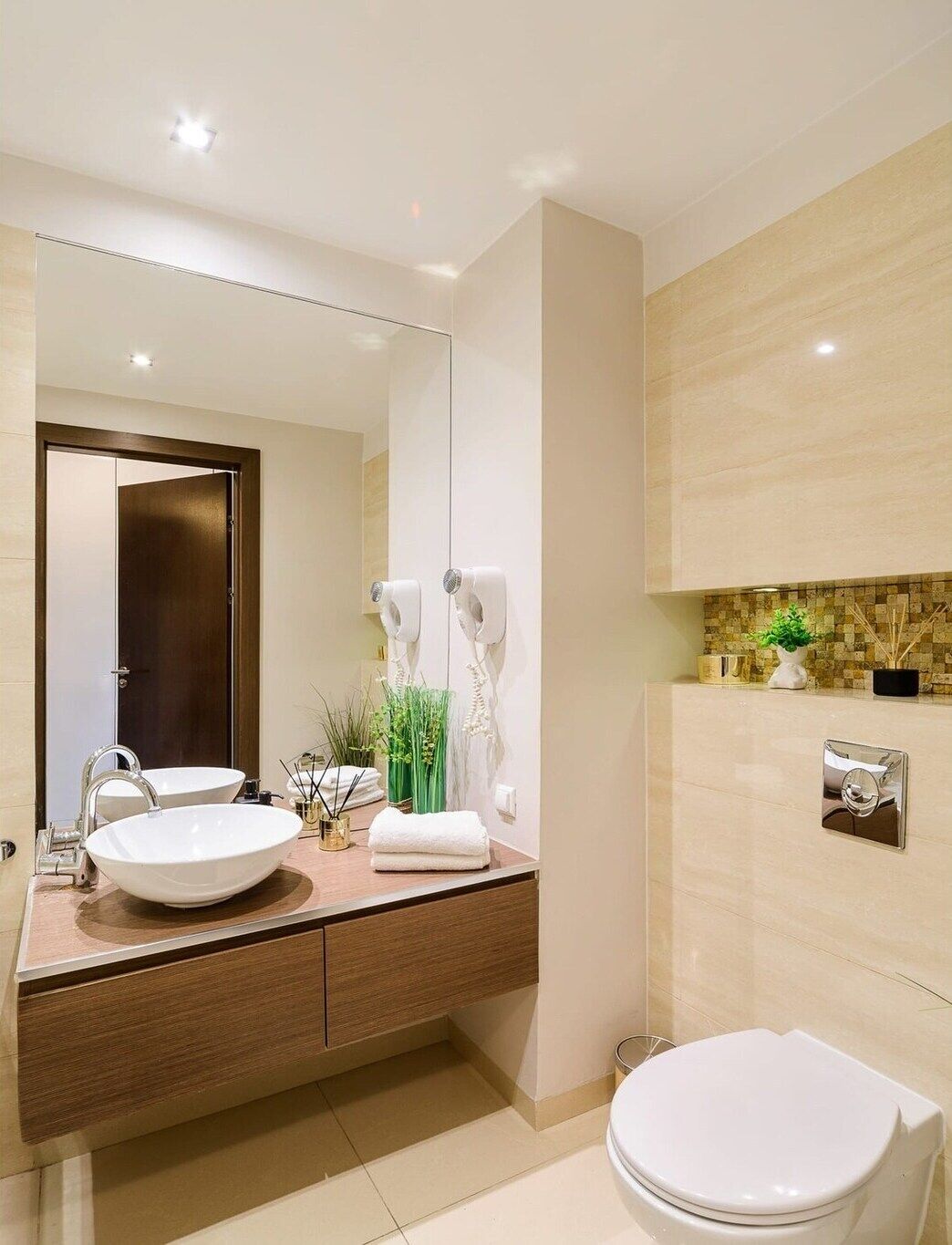 A modern bathroom with a double sink vanity, a toilet, and a mirror.