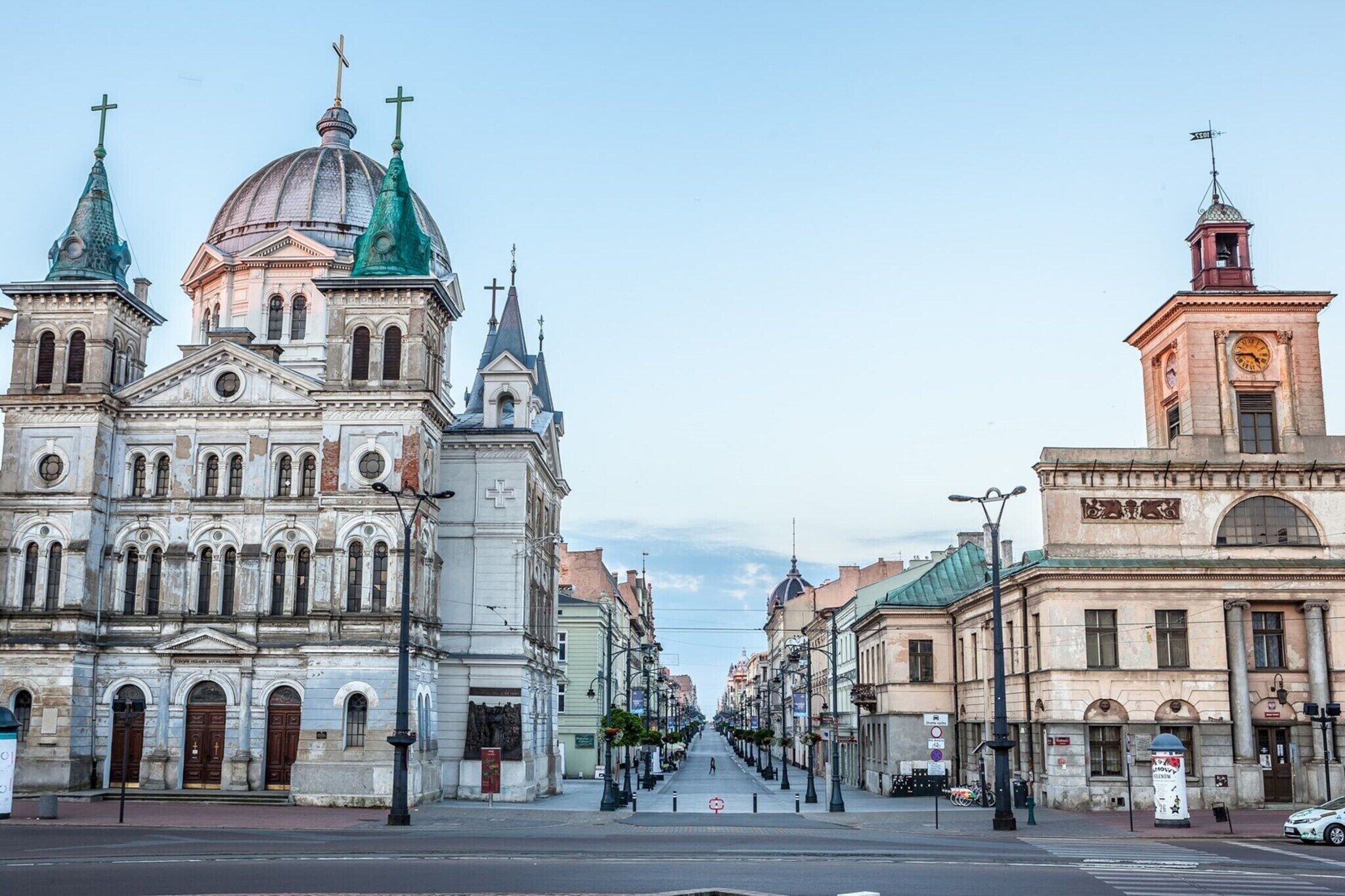 A street with historic buildings, including a church with a dome and a bell tower.