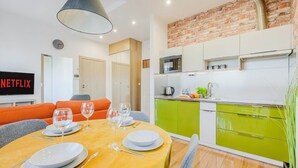 A modern kitchen with green cabinets, a microwave, and a sink. - Siedmiogrodzka Flat with Views (Warszawa)