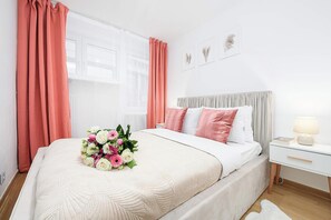 A bedroom with a bed, a nightstand, a lamp, and a window with curtains. - House in Brélès near Rock Beach & Amusement Park (Warszawa 2)