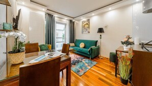 A modern living room with a green sofa, wooden coffee table, and a dining area with chairs and a table. - Flat near Metro, Warsaw (Warszawa)