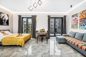 Ein modernes Hotelzimmer mit einem Bett, einem Esstisch und einer Couch.
