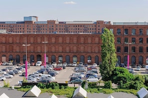 Ein Parkplatz mit mehreren Autos und einem großen Backsteinhaus im Hintergrund.