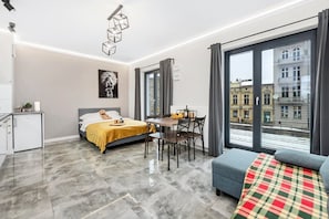 Ein modernes Hotelzimmer mit einem Bett, einem Esstisch und einer Couch.