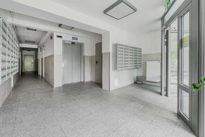 Um corredor com armários, uma porta e um radiador.