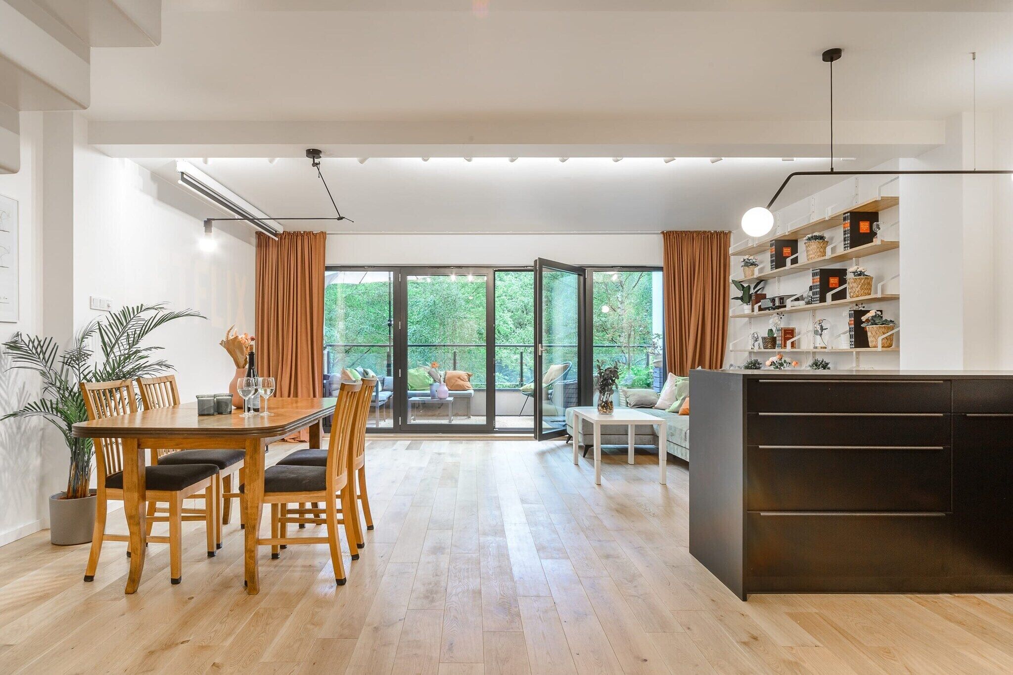 A modern interior with a dining area, a sofa, and a kitchen counter.