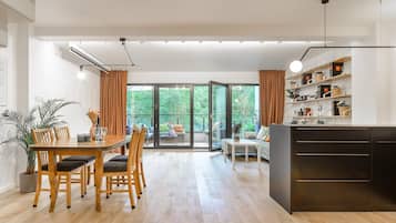 A modern interior with a dining area, a sofa, and a kitchen counter.