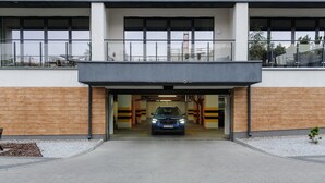 Una entrada de edificio moderno con un automóvil estacionado dentro.
