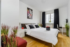 A hotel room with a bed, bedside tables, a window with curtains, and a painting on the wall. - Spacious Central Warsaw Apartment (Warszawa 2)