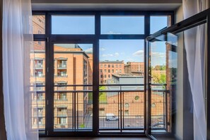 A window with a view of a cityscape, including buildings and a street. - Loft Flat in Historical Area (Łódź)