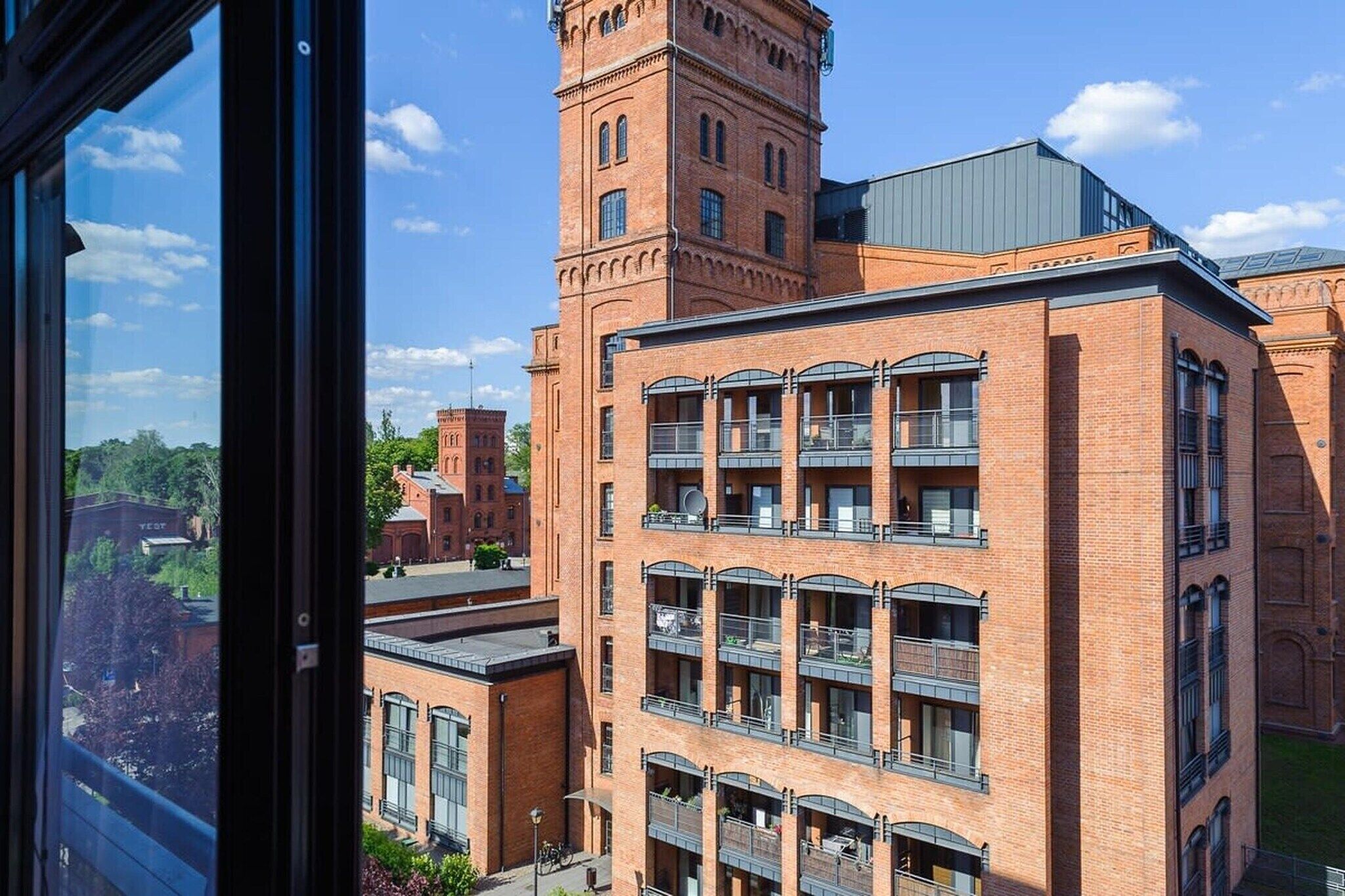 A multi-story building with a prominent tower and a flat-roofed section.