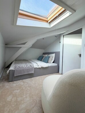 A bedroom with a skylight, a bed with pillows, and a door. - Lila Loft Bordeaux - Air-Conditioned Apartment in the Heart of the City Center (Bordeaux)