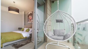 Ein Schlafzimmer mit einem Bett, einem Hängekorbstuhl und einem Fenster.