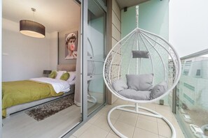 Ein Schlafzimmer mit einem Bett, einem Hängekorbstuhl und einem Fenster.