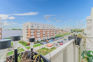 Ein mehrstöckiges Wohngebäude mit Balkonen, einem Parkplatz und blauem Himmel.
