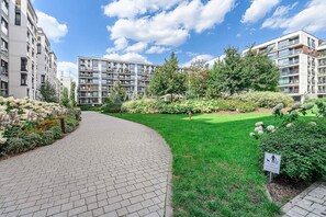 A residential area with multi-story buildings, a paved walkway, and well-maintained greenery. - Warsaw Flat with City Views (Warszawa 2)