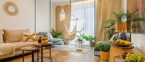A modern living room with a sofa, coffee table, and a dining area with fruit.