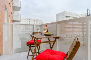 A rooftop terrace with a table, chairs, and a bottle of wine. - Old Town Apartment for 6 in Łódź (Łódź)