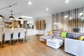 Ein modernes Wohnzimmer mit einer Couch, einem Hocker und einem Couchtisch.