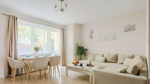 En moderne stue med sofa, spisebord, stole og sofabord.