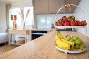 A fruit stand with strawberries and bananas on a wooden table in a modern kitchen. - Landliebe Lodges "Bienenstock" Vacation Home - Country Life, Dinopark, Hollandpark, Thermal Baths (Löwenberger Land)