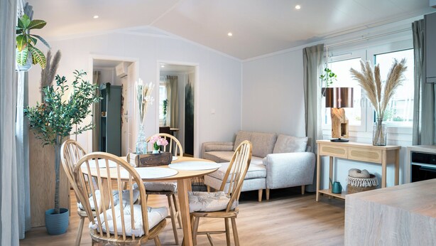 Een moderne woonkamer met een eethoek, een bank en een salontafel.