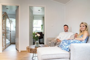 Ein modernes Wohnzimmer mit einer Couch, einem Couchtisch und einer Treppe, die in ein weiteres Geschoss führt.