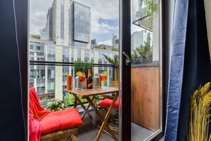 A balcony with a table, chairs, and a view of city buildings. - Quiet Flat with Garage (Warszawa 2)