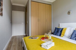 Ein Schlafzimmer mit einem Bett, einem Nachttisch mit einer Zeitschrift, einer Flasche und Gläsern.