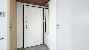A white door with a black frame, a wooden door frame, and a metal handle. - Lush Home near Varso Tower (Warszawa)