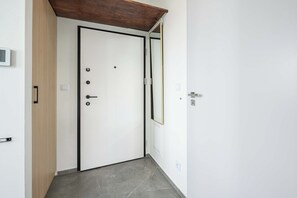 Eine weiße Tür mit schwarzem Rahmen, ein hölzerner Türrahmen und ein Metallbeschlag.