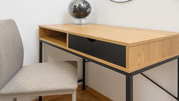 A wooden desk with a black drawer and a globe on top, a grey chair, and a herringbone-patterned floor. - Magnificent Beach House for 6 (Warszawa)